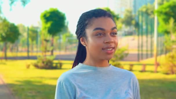 Porträt der attraktiven Mischlingsstudentin schlendert glücklich lächelnd - Filmmaterial, Video