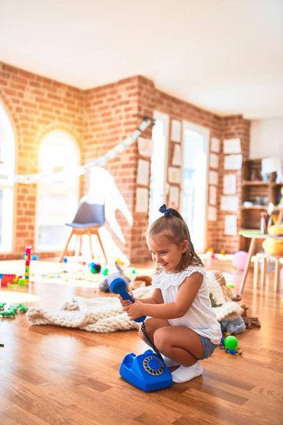Молода красива блондинка дитина насолоджується грою в школу з іграшками в дитячому садку, посміхаючись щасливою грою вдома
 - Фото, зображення