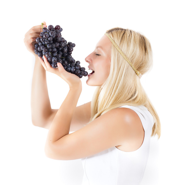 Attractive blonde woman eating grapes - Photo, Image