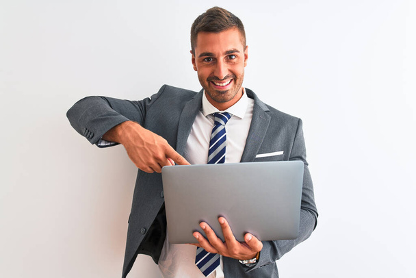 Jeune homme d'affaires beau travaillant à l'aide d'un ordinateur portable sur fond isolé très heureux pointage avec la main et le doigt
 - Photo, image