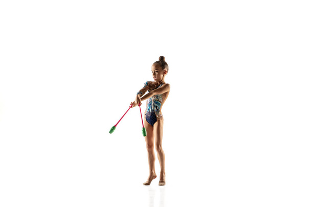 Little flexible female gymnast isolated on white studio background - Foto, immagini