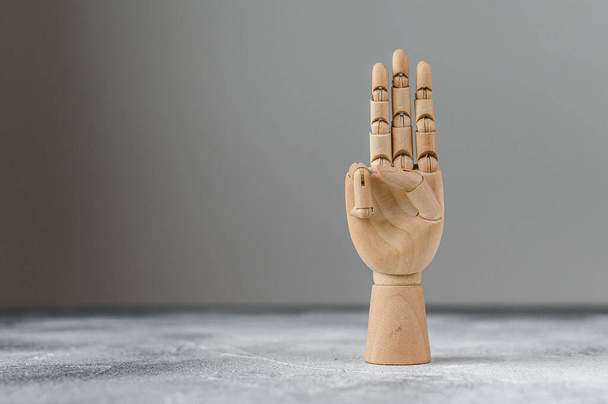 La mano de madera muestra tres dedos levantados. El concepto de comunicación
. - Foto, imagen