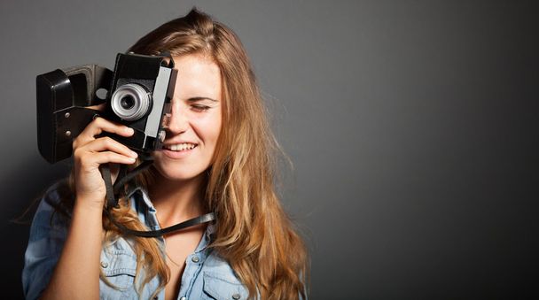 Smiling photographer woman taking pictures old camera - 写真・画像