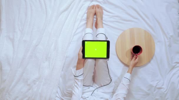 fêmea em pijama branco usar gadget beber café
 - Filmagem, Vídeo