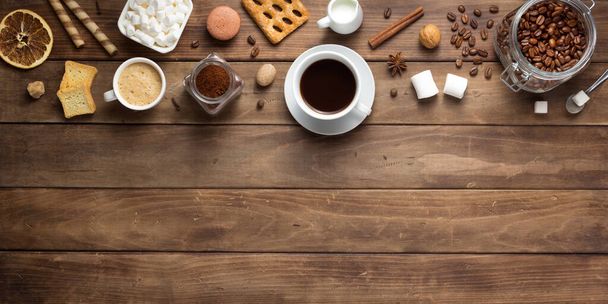 cup of coffee and beans on wooden background - Foto, afbeelding