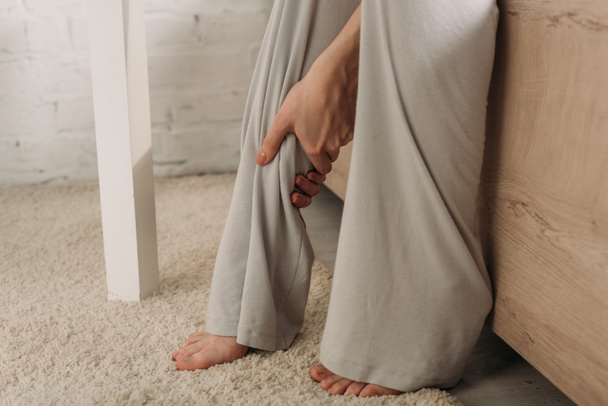 przycięty widok kobiety dotykającej nogi cierpiącej na ból - Zdjęcie, obraz