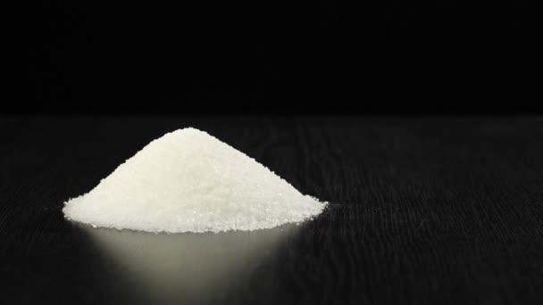 Kubus bruine suiker wordt in een hoop witte suiker gegooid met spatten. - Video