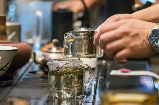 Barista uros kädet pitämällä lasi teekannu teetä säikeet kahvila laskuri Busan, Etelä-Korea
 - Valokuva, kuva
