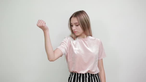 attraktive Frau mit hübschem Hemd, die auf Händen schaut und ihre Muskeln ausprobiert - Filmmaterial, Video