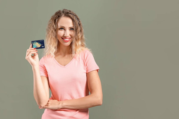 Молодая женщина с кредитной картой на цветном фоне
 - Фото, изображение
