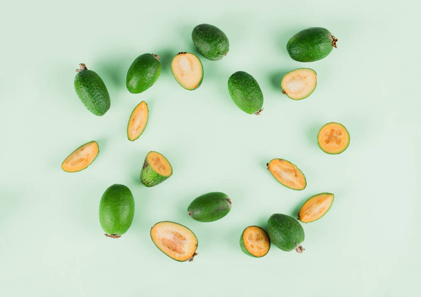Fresh feijoa fruits with slices on a mint background. Fruit content - Photo, Image