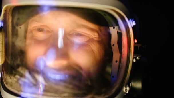 Astrounaut Mann mit Helm blickt voraus und erkundet die Erde im Dunkeln - Foto, Bild