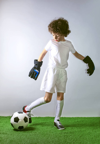 Photo of smiling little boy with a soccer ball - posing in studio - Foto, Bild