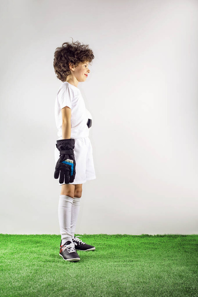 Boy goalkeeper stands with a soccer ball. side view. Copy space for inscription. - Foto, Bild