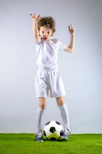 Little boy footballer in presenting and inviting to come spotrivnoy shape to play with him on a light background. - Fotografie, Obrázek