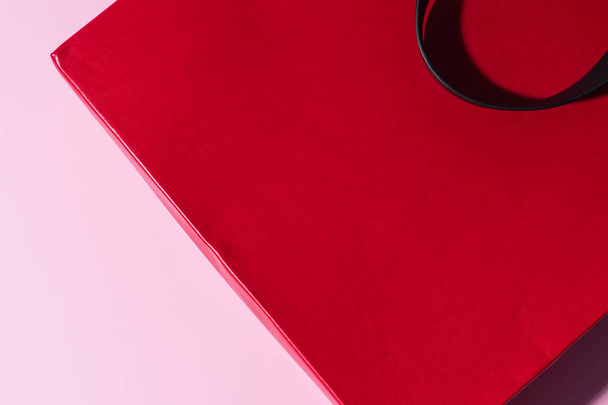 Красная кожаная сумка с черной ручкой на розовом фоне. Свободное место для логотипа или рекламы. Пакет для покупок
. - Фото, изображение