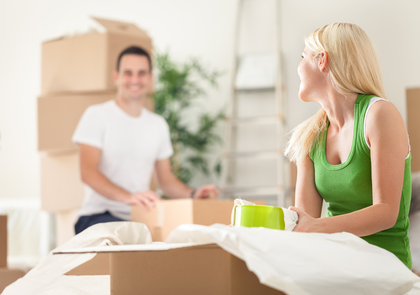 Young couple unpacking moving boxes - 写真・画像