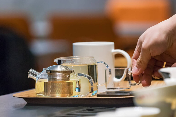 Barista uros kädet asettamalla lasi kuppi tarjotin teekannuja kahvilassa tiskillä Busan, Etelä-Korea
 - Valokuva, kuva
