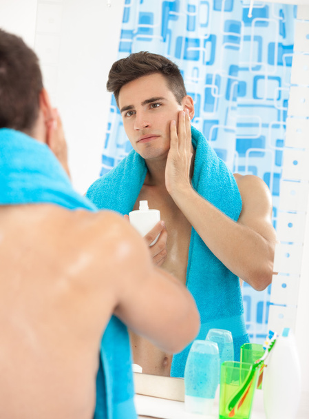 Young man applying after shave - Valokuva, kuva