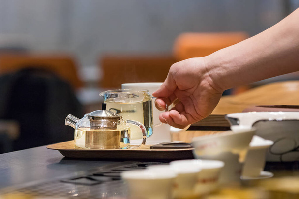 Barista uros kädet sijoittamalla lasi teekannu teetä säikeet tarjottimella kahvila laskuri Busan, Etelä-Korea
 - Valokuva, kuva