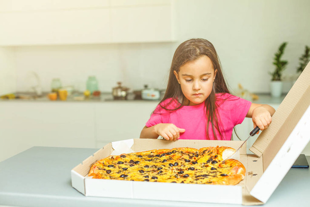 маленька дівчинка з великою піцою вдома
 - Фото, зображення