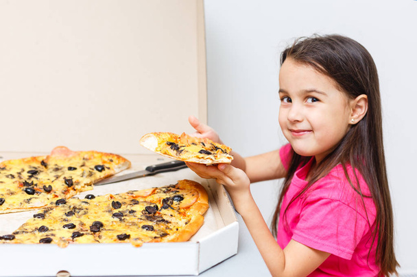 κοριτσάκι με μεγάλη πίτσα στο σπίτι. - Φωτογραφία, εικόνα