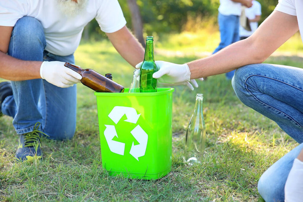 Menschen, die im Freien Müll sammeln. Recyclingkonzept - Foto, Bild