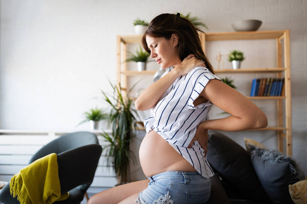 Pregnant woman expecting baby with aches, headache and backpain - Zdjęcie, obraz