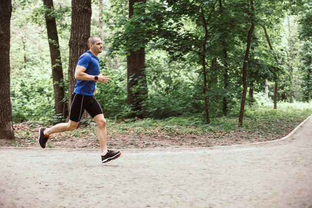 Man training and running in the forest or urban park - Φωτογραφία, εικόνα