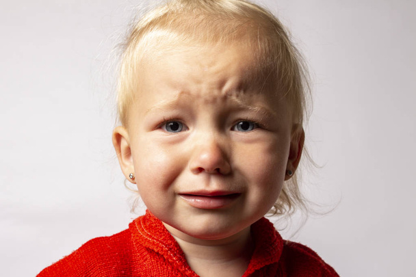 Małe dziecko płacze na jasnym tle. Koncepcja złego nastroju, niegrzeczne dziecko, zęby rosną - Zdjęcie, obraz