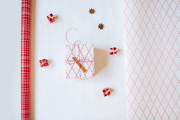 Christmas gift paper and a wrapped gift on white background. Flatlay. - Foto, Imagem