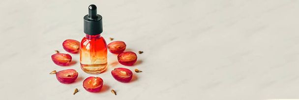 Виноградное масло. Творческий натюрморт винограда, семян и бутылки на светлом фоне. Плоский лежал. Баннер
 - Фото, изображение
