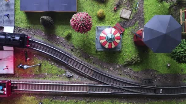 Horní pohled na pohybující se model parní lokomotivy. Detailní model peron a vlakového nádraží. Detailní záběr minek - Záběry, video