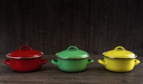 olla de cocina de color en escritorio de madera
 - Foto, Imagen