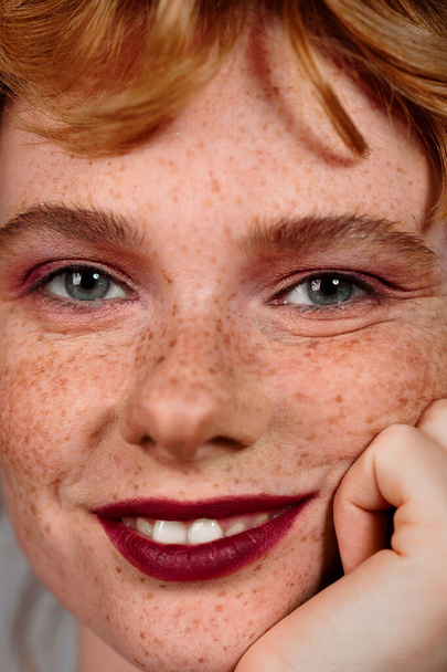 Closeup macro portrait of female face. Human woman half-face with day beauty makeup. Girl with perfect skin and freckles. - 写真・画像