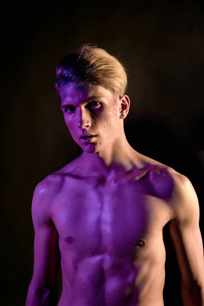 Handsome pumped up guy with naked torsos. Sports guy, attractive male body. Studio shooting with color filters - 写真・画像
