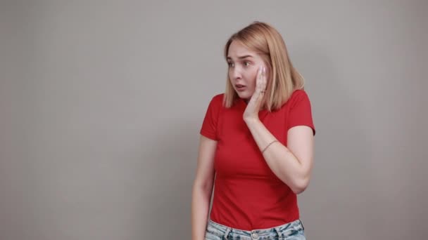 hübsche junge Frau in rotem Hemd posiert, skeptischer Blick schockiert - Filmmaterial, Video