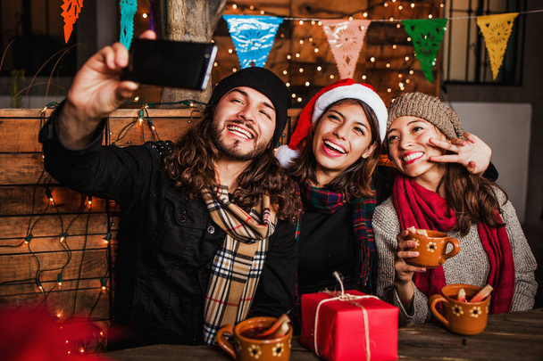 Mexican Posada friends celebrating Christmas in Mexico and taking a photo selfie - Photo, Image