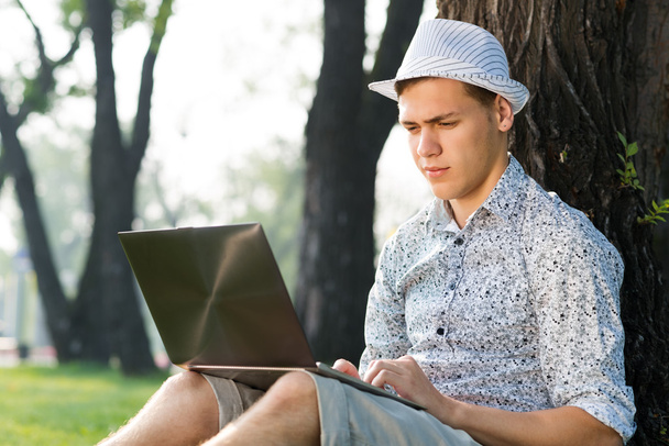 young man working in the park with a laptop - Fotoğraf, Görsel