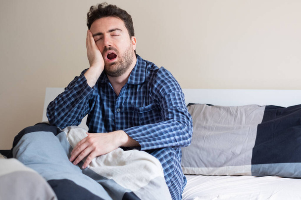 Man feeling tired in the morning after a bed sleep - Photo, Image