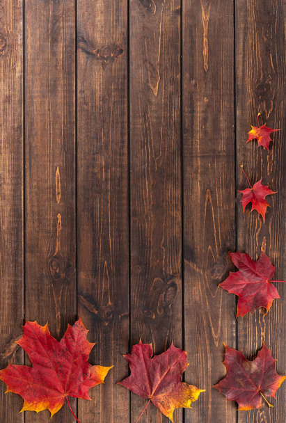 Φθινοπωρινή σύνθεση. Έξι κόκκινα φύλλα σφενδάμου από μικρά έως μεγάλα ως πλαίσιο σε σκούρο ξύλινο καφέ φόντο. Η ιδέα της ημέρας Ευχαριστιών. Επίπεδο lay, πάνω όψη, αντιγραφή χώρου - Φωτογραφία, εικόνα
