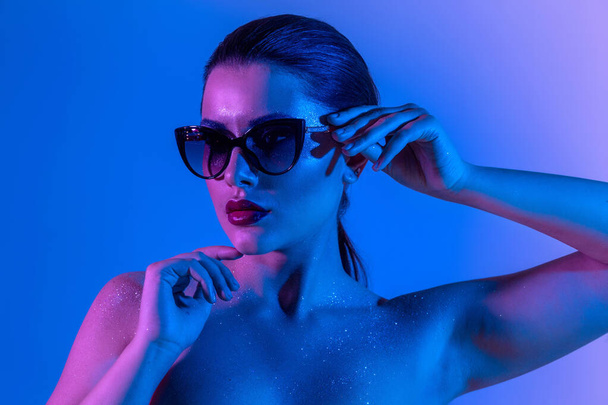 Μοντέρνα γυναίκα με γυαλιά ιριδίζουσα φόντο κόμμα ντίσκο στυλ γυμνοί ώμοι - Φωτογραφία, εικόνα