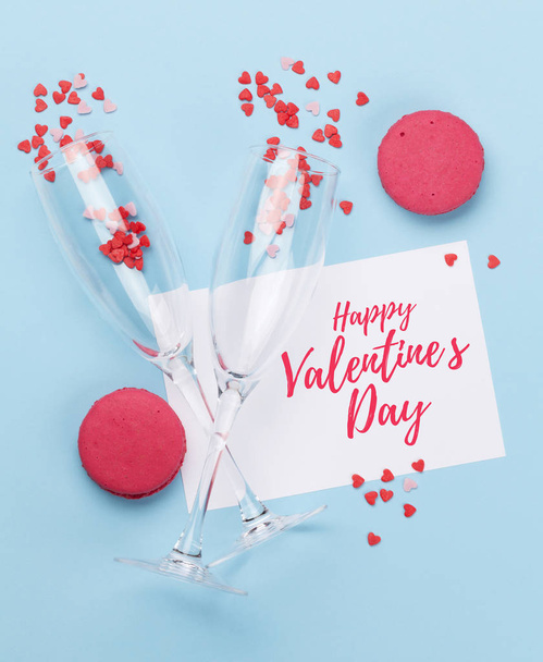 Champagne glasses, greeting card and heart shaped sweets holiday template. Valentines'day card over blue background. Top view. Flat lay - Foto, immagini