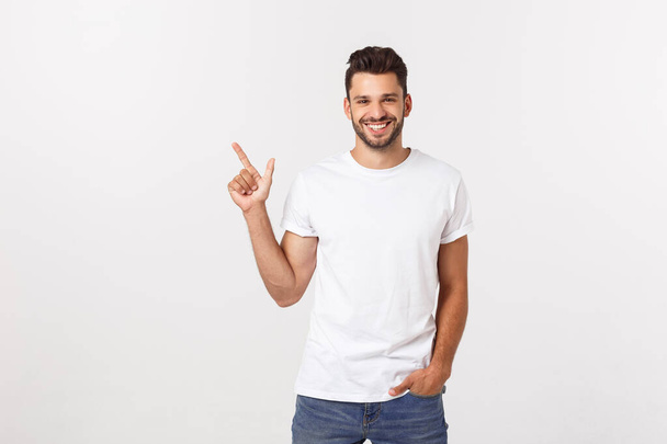 Man pointing showing copy space isolated on white background. Casual handsome Caucasian young man. - Fotoğraf, Görsel