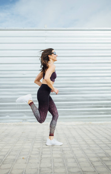 Beautiful woman running in the city. Fitness, workout, sport, lifestyle concept - 写真・画像