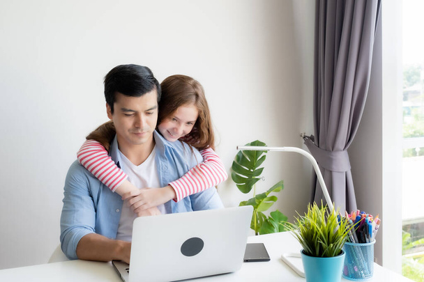 Mavi gömlekli sıradan bir adam ve kızıyla birlikte dizüstü bilgisayar kullanıyor. - Fotoğraf, Görsel