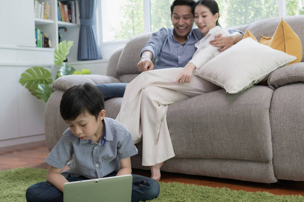 Asyalı aile babası, anne ve oğlu bilgisayar oyunu oynuyorlar. - Fotoğraf, Görsel