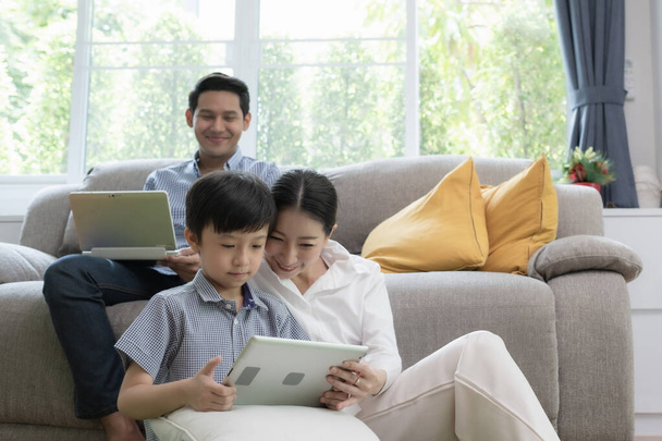 Азиатские отец, мать и сын, играющие на ноутбуке
 - Фото, изображение