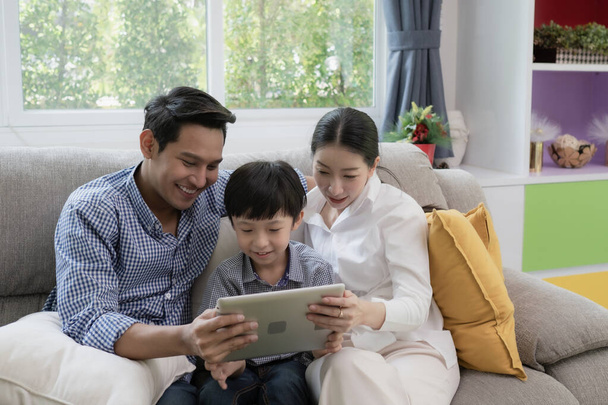 Азиатские отец, мать и сын, играющие на ноутбуке
 - Фото, изображение