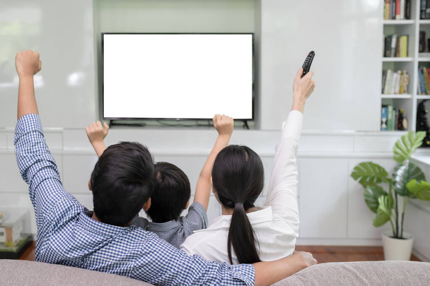 Visão traseira da jovem família, homem e mulher assistindo TV juntos em
 - Foto, Imagem